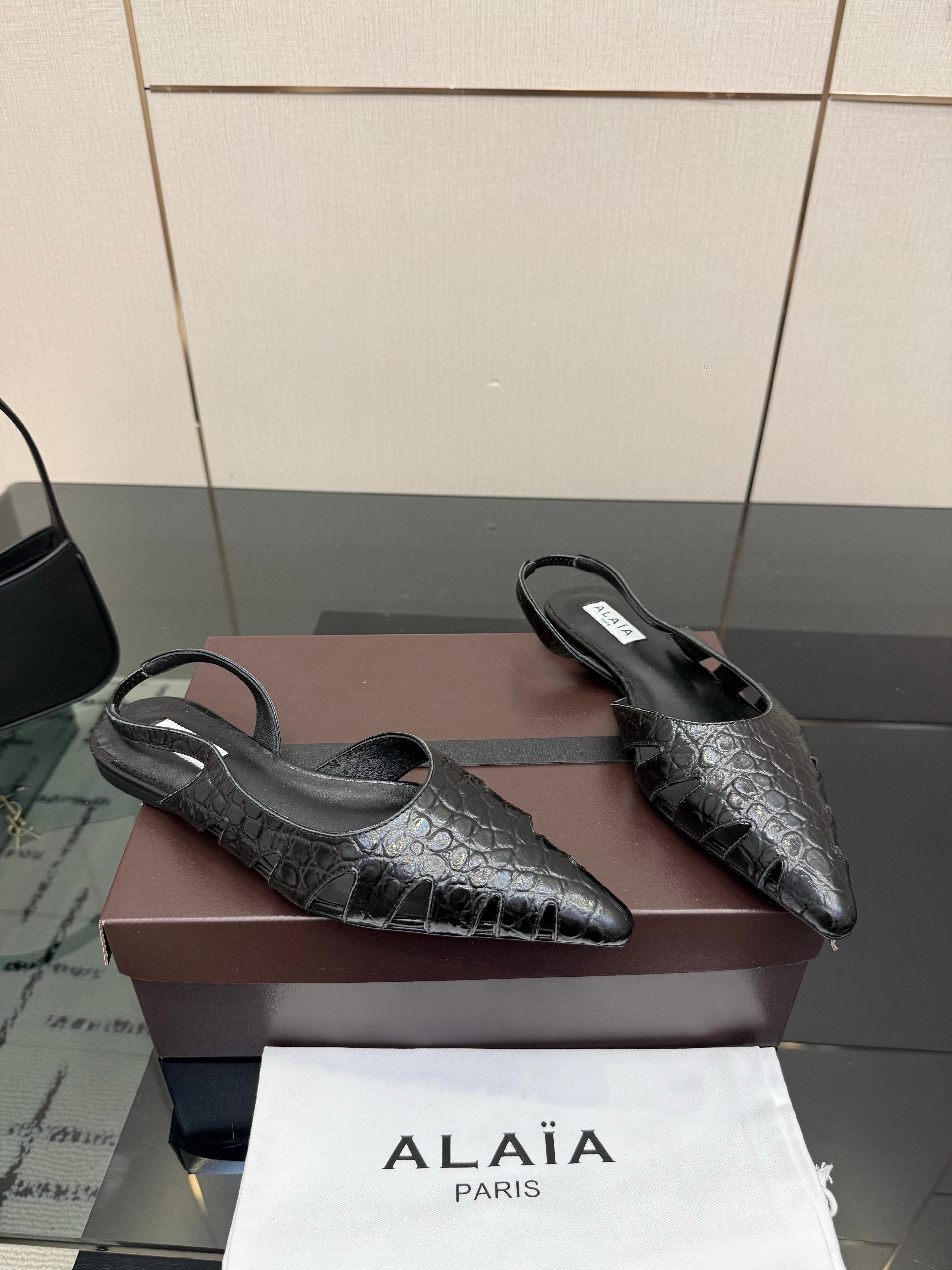 ALAIA 26S CUT-OUT SLINGBACK FLATS IN BLACK CROC-EMBOSSED LEATHER