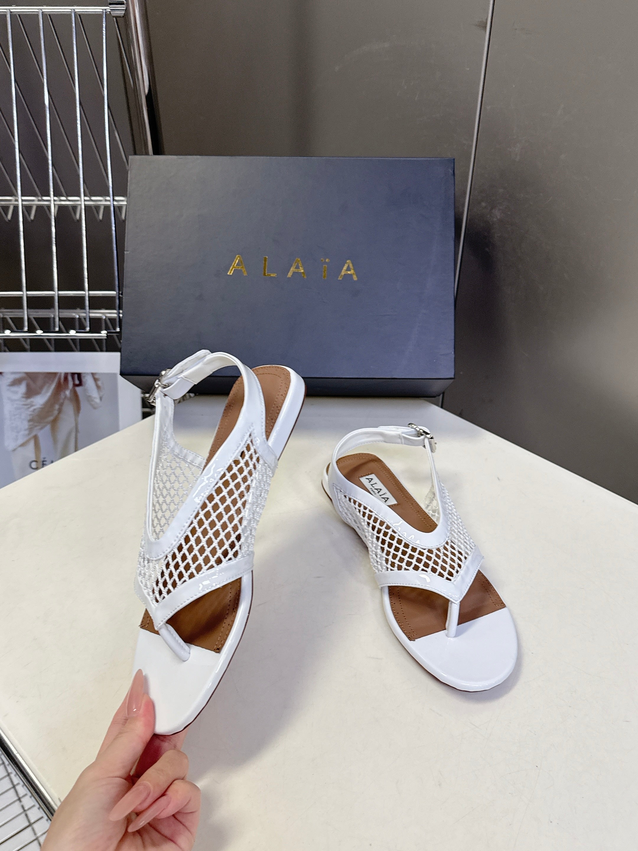 ALAIA 26S FLAT MESH THONG SANDALS IN WHITE PATENT CALFSKIN