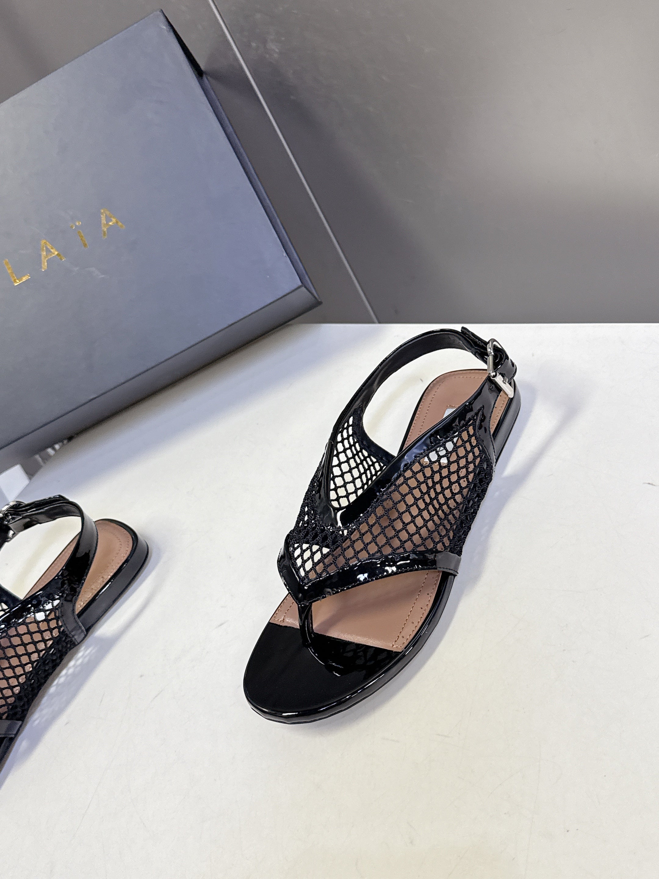 ALAIA 26S FLAT MESH THONG SANDALS IN BLACK PATENT CALFSKIN
