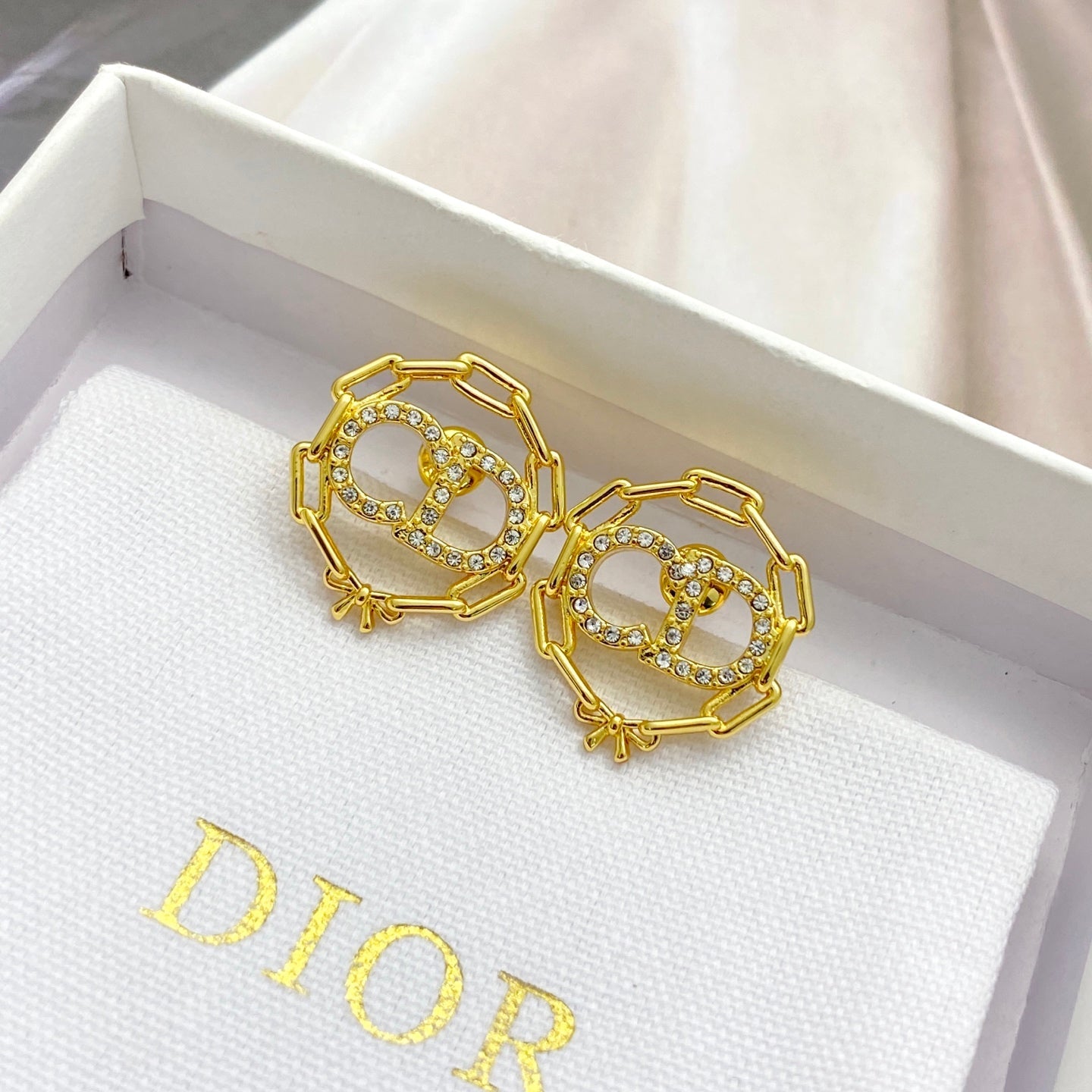 CD 26S CRYSTAL CHAIN LOGO STUD EARRINGS IN GOLD TONE METAL 645655