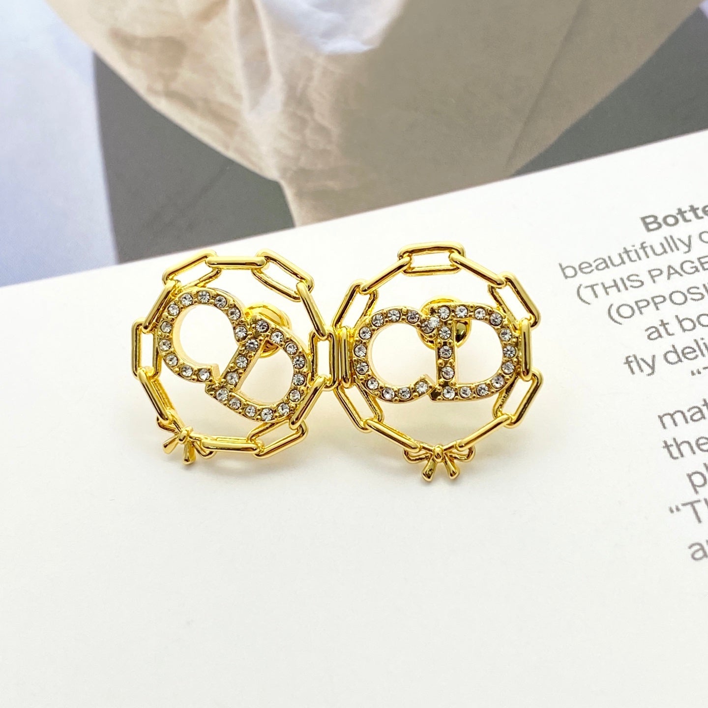CD 26S CRYSTAL CHAIN LOGO STUD EARRINGS IN GOLD TONE METAL 645655